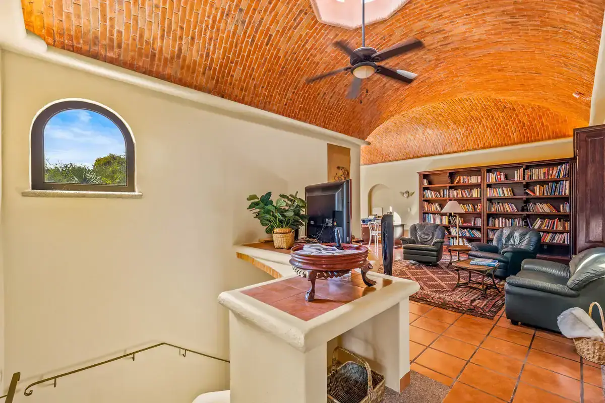 Lakefront Rancho Home Interior Cozy living room with vaulted brick ceiling and large bookshelf in Rancho Los Labradores.