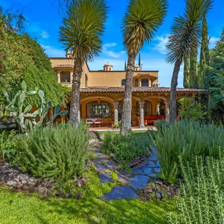 Beautiful lakefront home in Rancho Los Labradores, San Miguel de Allende, surrounded by lush gardens.