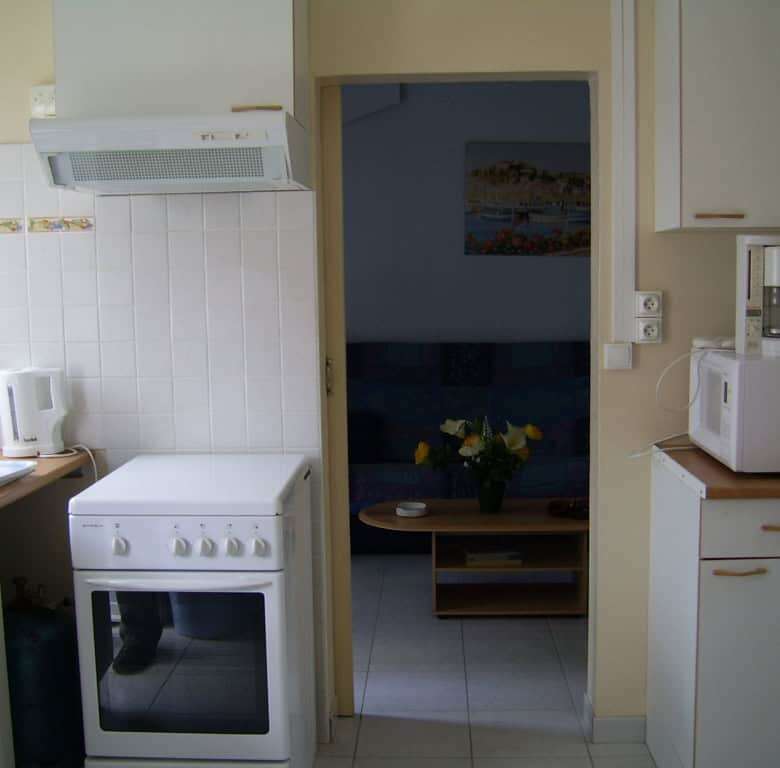 Bright kitchen with modern appliances and a view into the living area in Mers Les Bains.
