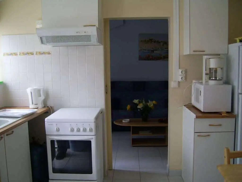Bright kitchen with modern appliances and a view into the living area in Mers Les Bains.