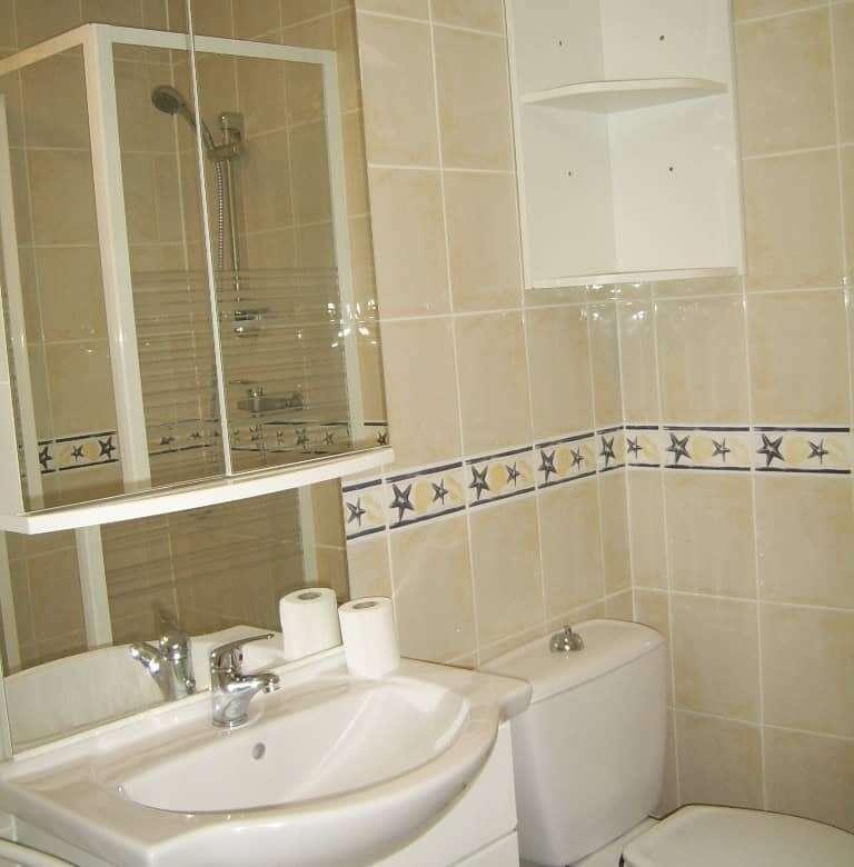 Bright bathroom in seaside property with modern fixtures and shower enclosure.