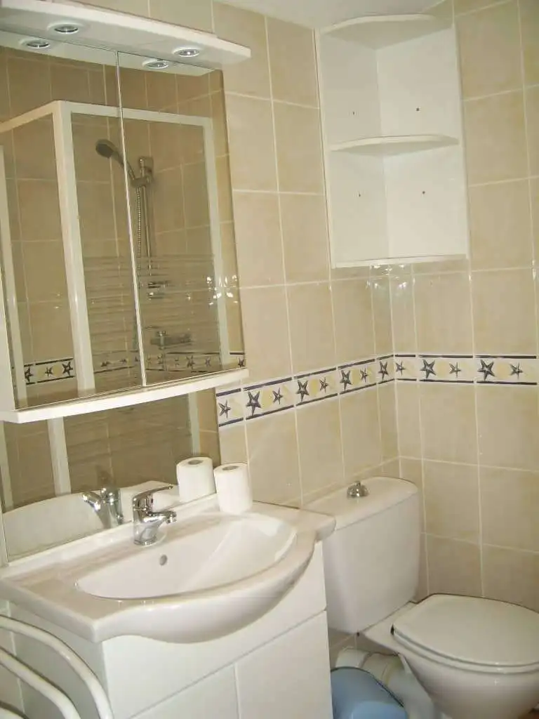 Bright bathroom in seaside property with modern fixtures and shower enclosure.