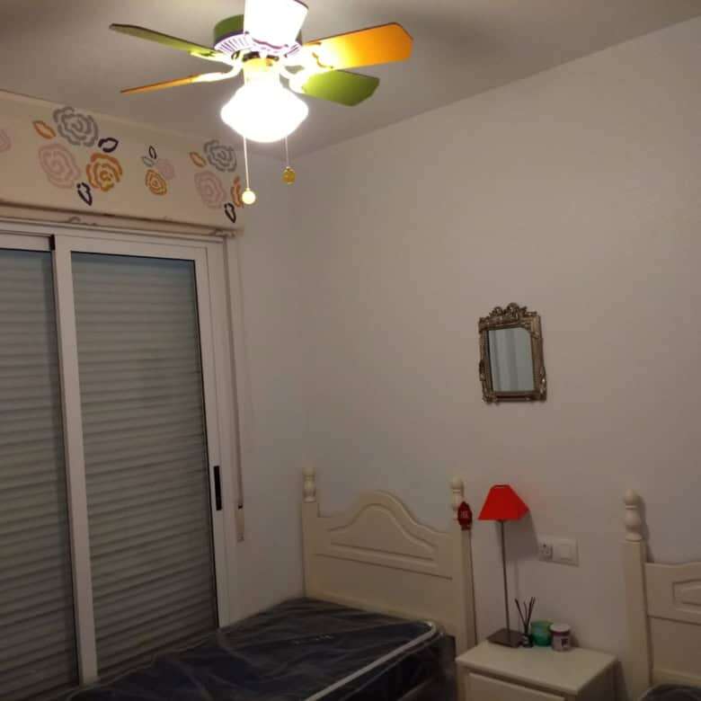 Interior view of a modern 2-bedroom penthouse in Torrevieja with a cozy bedroom and ceiling fan.