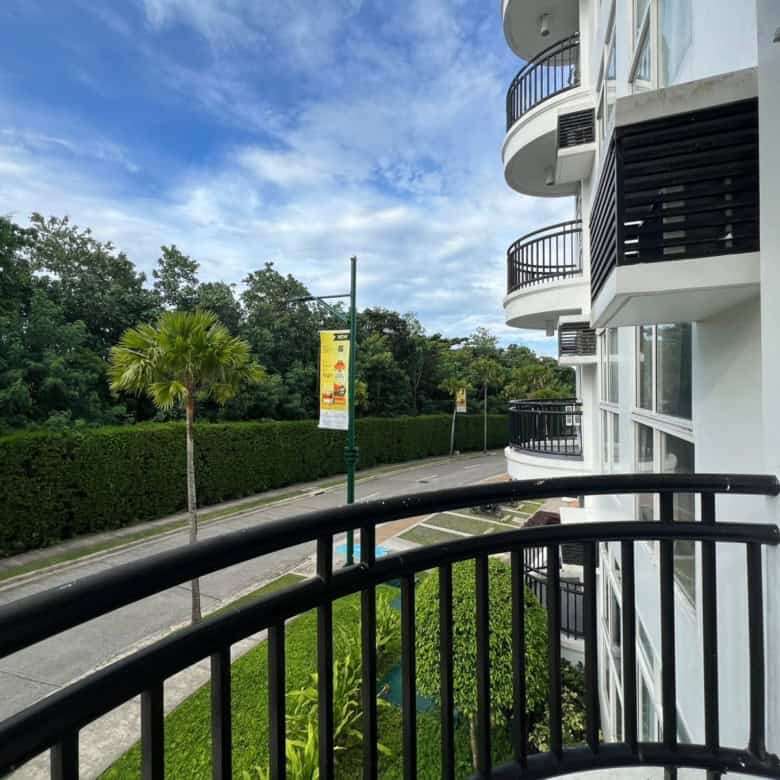 Bright apartment balcony overlooking lush greenery and a quiet street in Boracay.