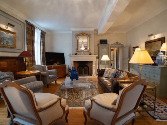 Elegant living room with classic furniture and warm lighting in a French house.