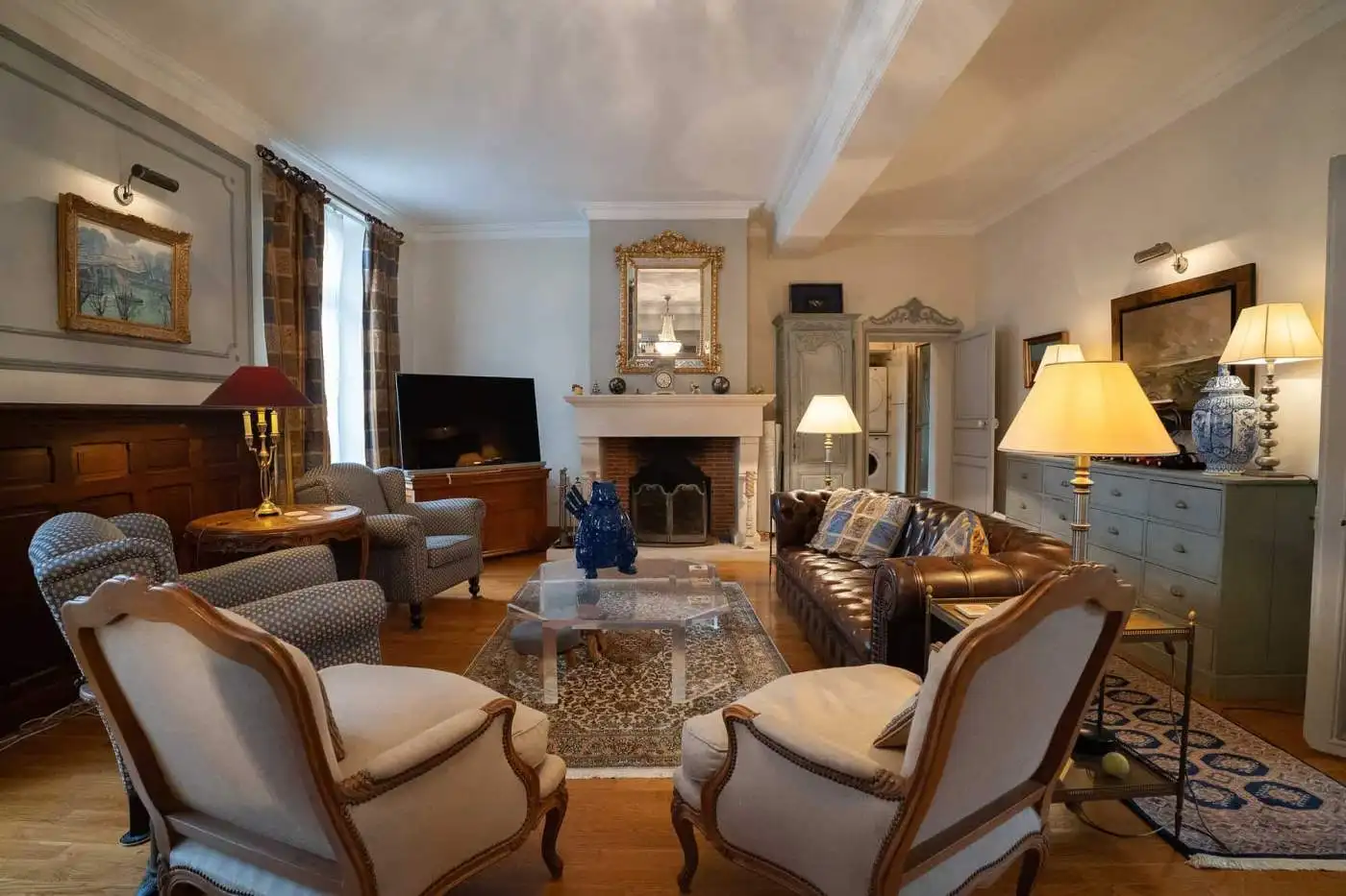 Elegant living room with classic furniture and warm lighting in a French house.