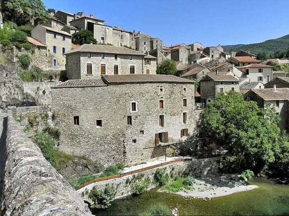 Ancient stone houses in Olargues, Herault, France, with scenic river view.