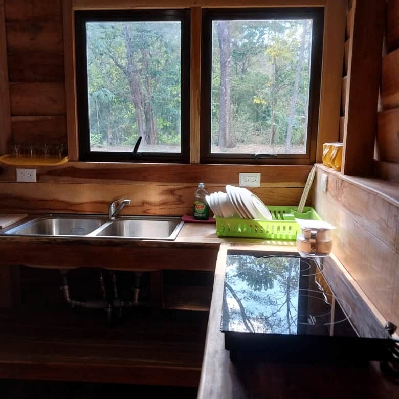 Charming wooden kitchen with large windows overlooking lush forest in Vainilla, Costa Rica. Perfect.