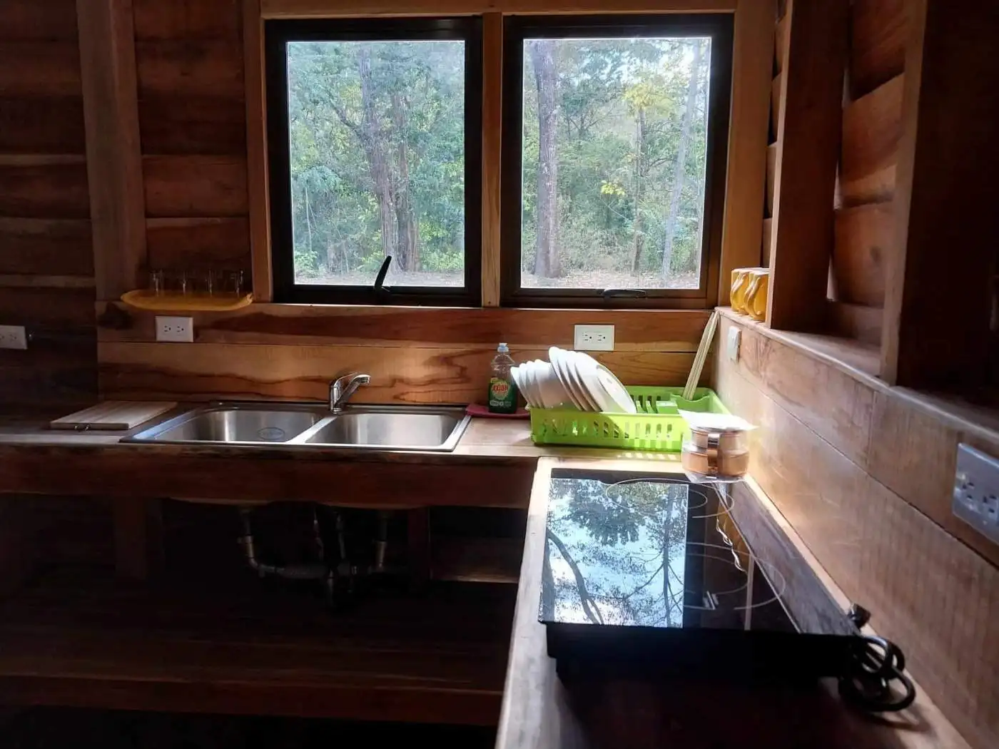 Charming wooden kitchen with large windows overlooking lush forest in Vainilla, Costa Rica. Perfect.