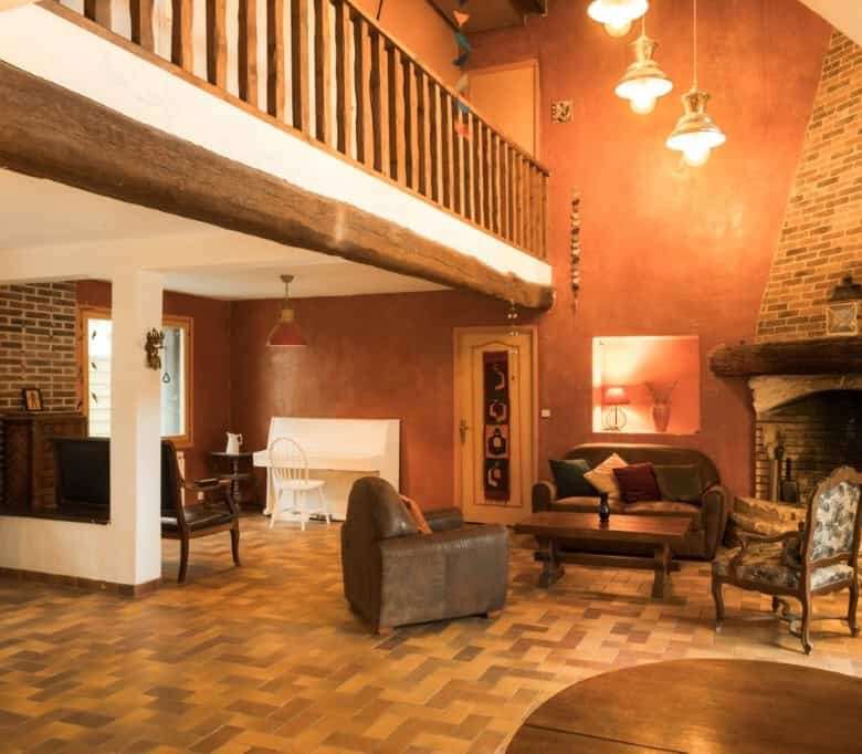 Elegant living room with rustic stone fireplace and wooden accents in La Celle-sur-Morin estate.
