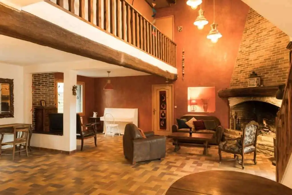 Elegant living room with rustic stone fireplace and wooden accents in La Celle-sur-Morin estate.