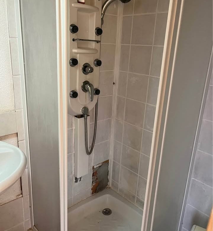 Compact shower unit with multiple jets in a mobile home bathroom.