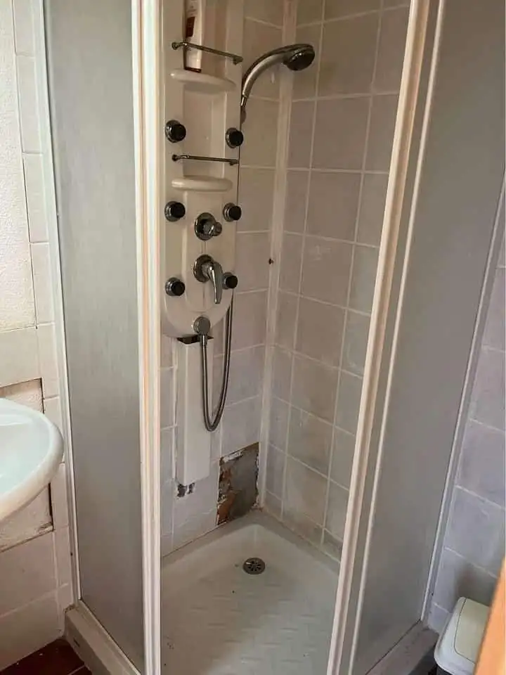 Compact shower unit with multiple jets in a mobile home bathroom.