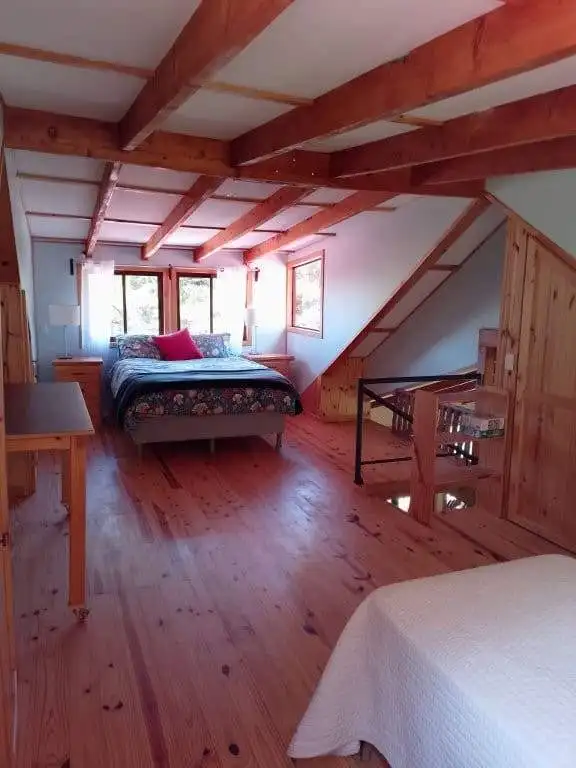 Cozy bedroom with wooden beams and natural light in Rio Blanco, Costa Rica.