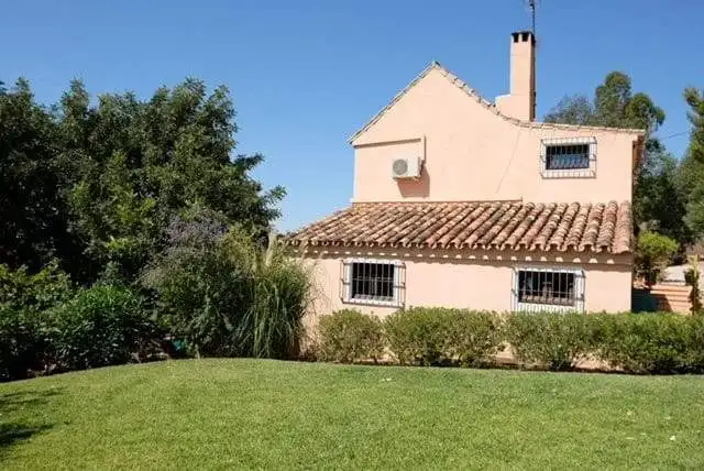 Charming 3-bedroom finca for sale in Estepona with lush garden and traditional Spanish architecture.