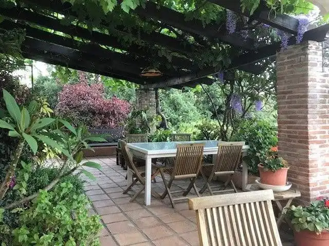 Outdoor dining area surrounded by vibrant plants and flowers in Estepona, Spain.