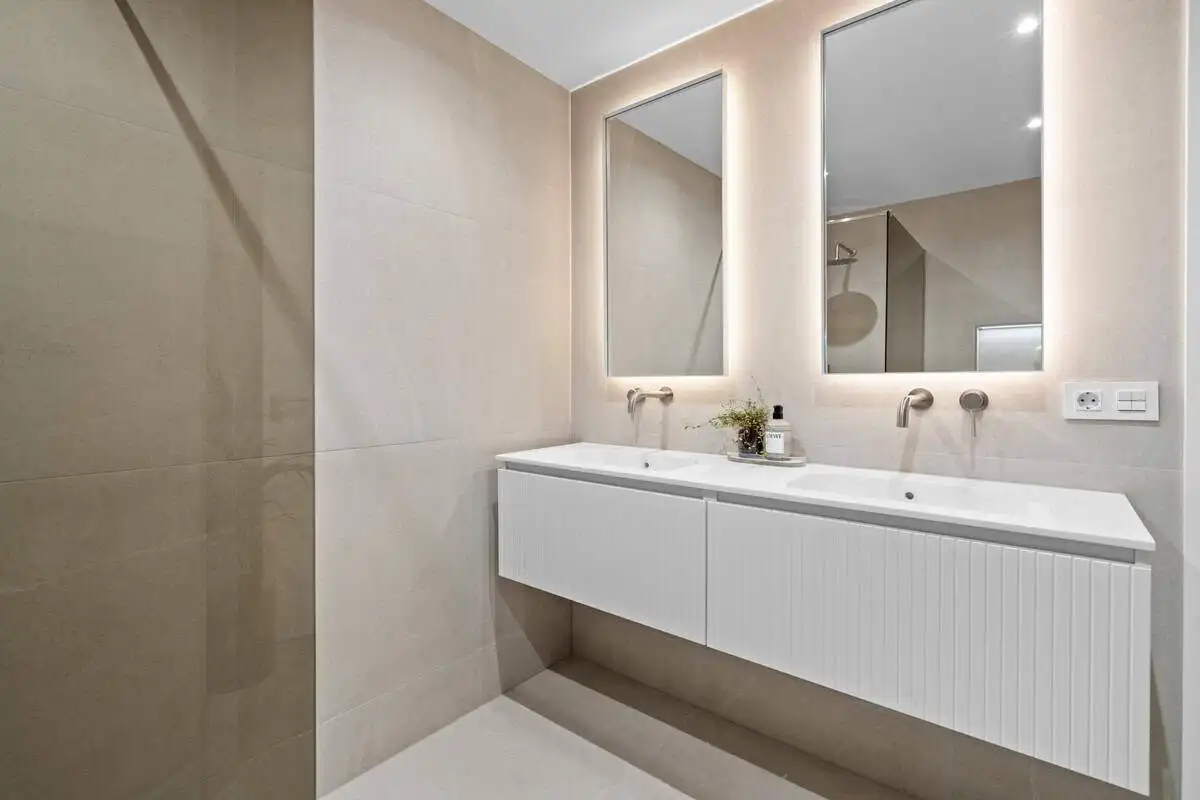 Modern bathroom with double sink vanity and large mirrors in a stylish apartment in Costa del Sol, S.