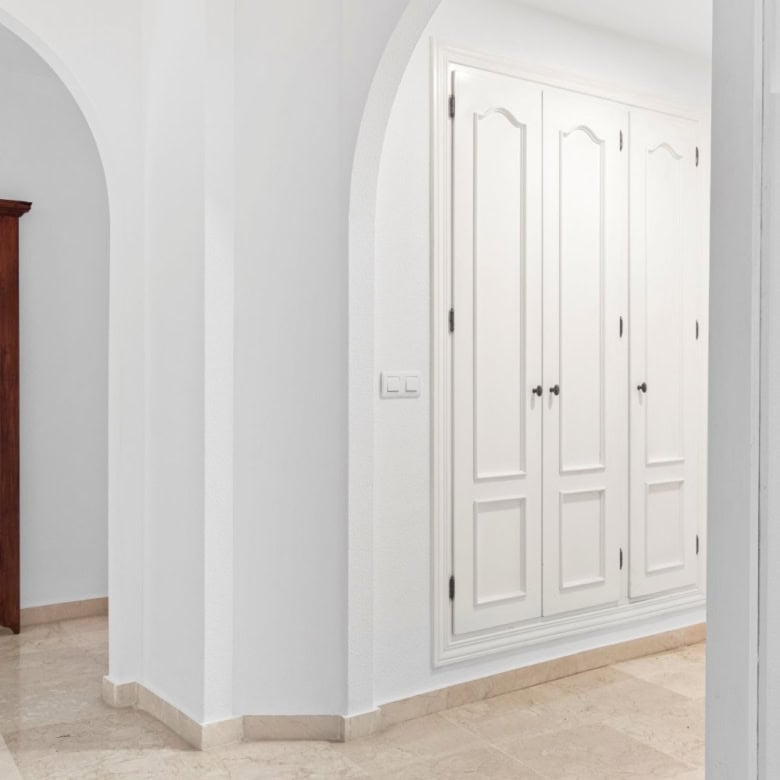 Beachfront property with elegant white wardrobes and spacious interiors.