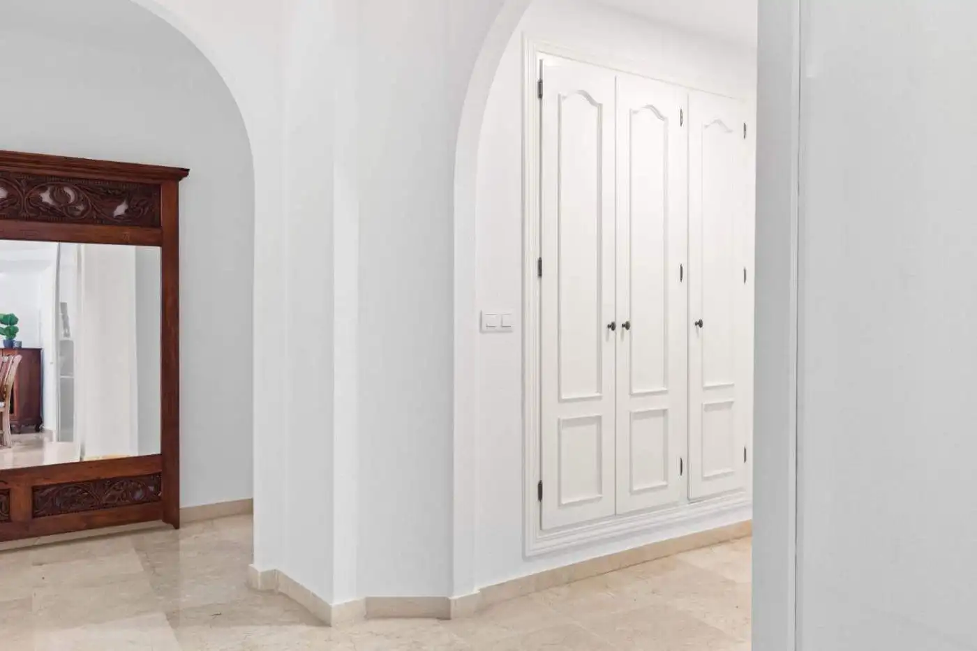 Beachfront property with elegant white wardrobes and spacious interiors.