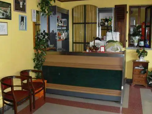 Hotel reception with wooden decor, plants, and cozy atmosphere in Piverone, Italy.