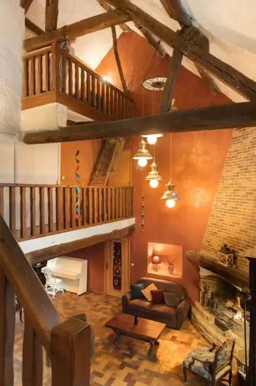 Cozy interior of a 6-bed estate with stone houses, featuring wooden beams and warm lighting.