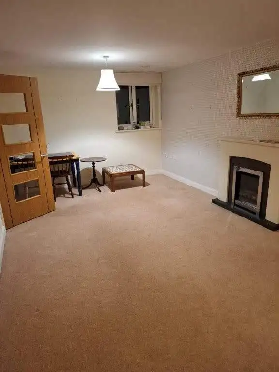Bright living room with fireplace and window in Coppice Gate complex, Dibden Purlieu, Hampshire, UK.