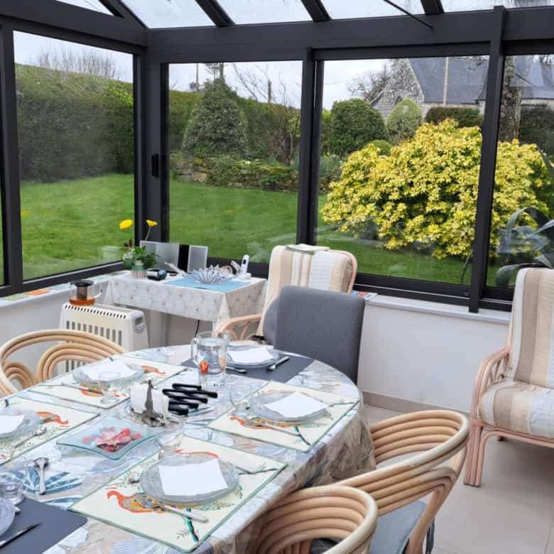Elegant conservatory with garden views and stylish dining setup.