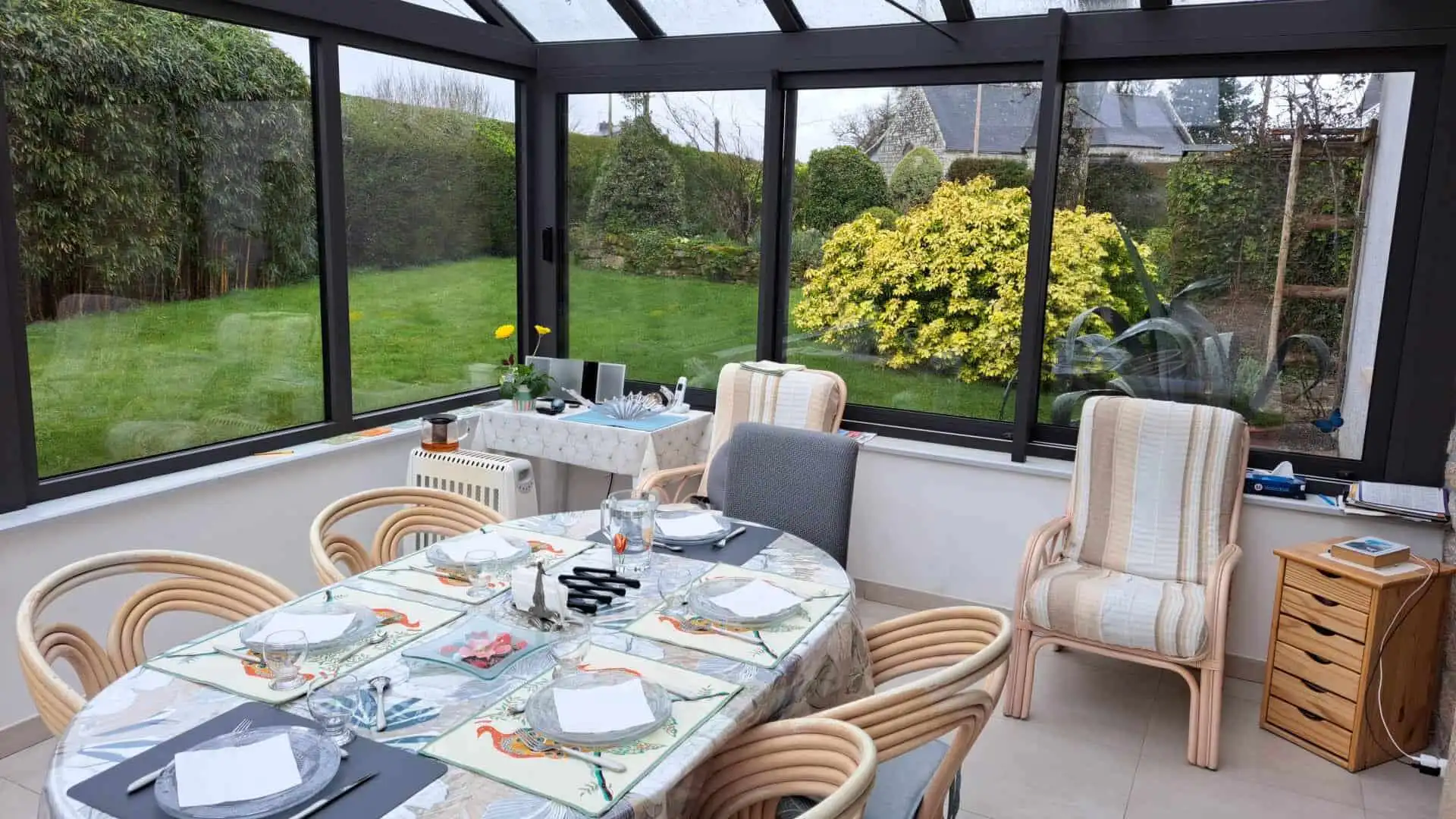 Elegant conservatory with garden views and stylish dining setup.