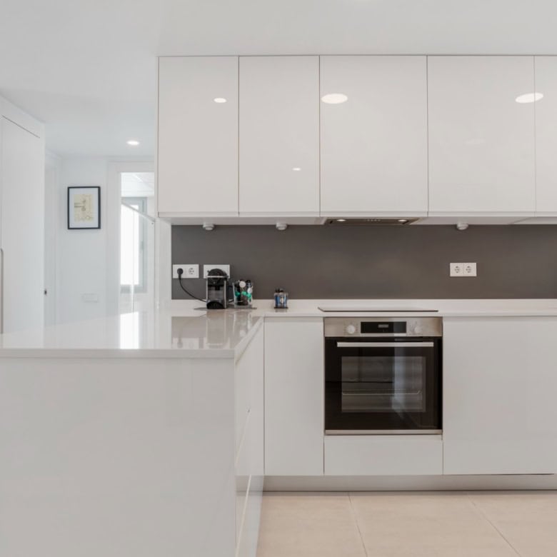 Modern kitchen with sleek white cabinets and built-in appliances in Selwo Estepona.