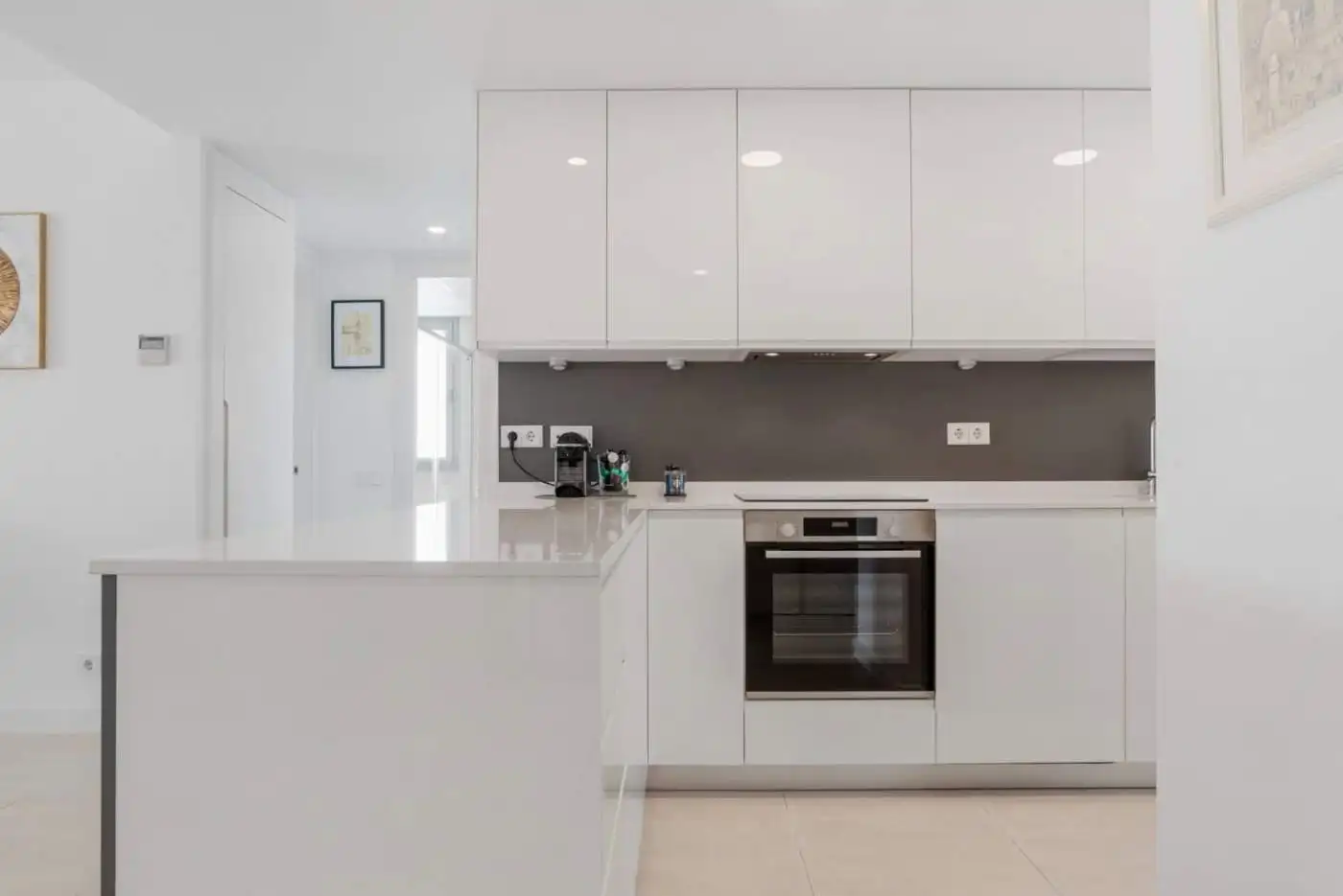 Modern kitchen with sleek white cabinets and built-in appliances in Selwo Estepona.