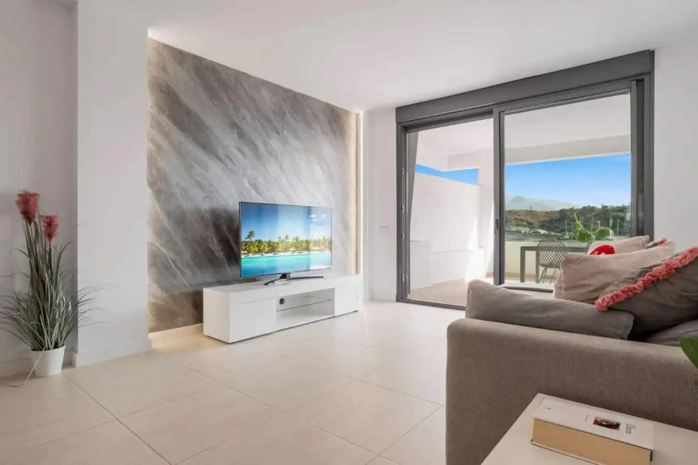 Bright living room with large sliding glass doors opening to a balcony in Selwo Estepona.