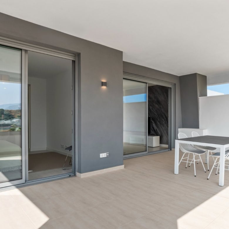 Spacious terrace of modern 2-bedroom penthouse in Selwo Estepona with outdoor dining area.