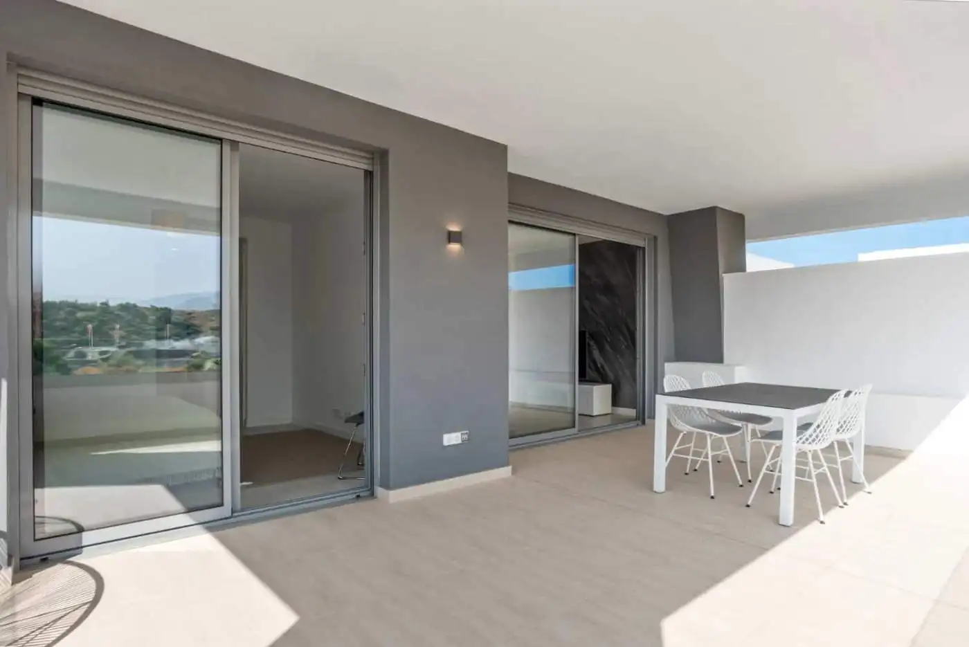Spacious terrace of modern 2-bedroom penthouse in Selwo Estepona with outdoor dining area.