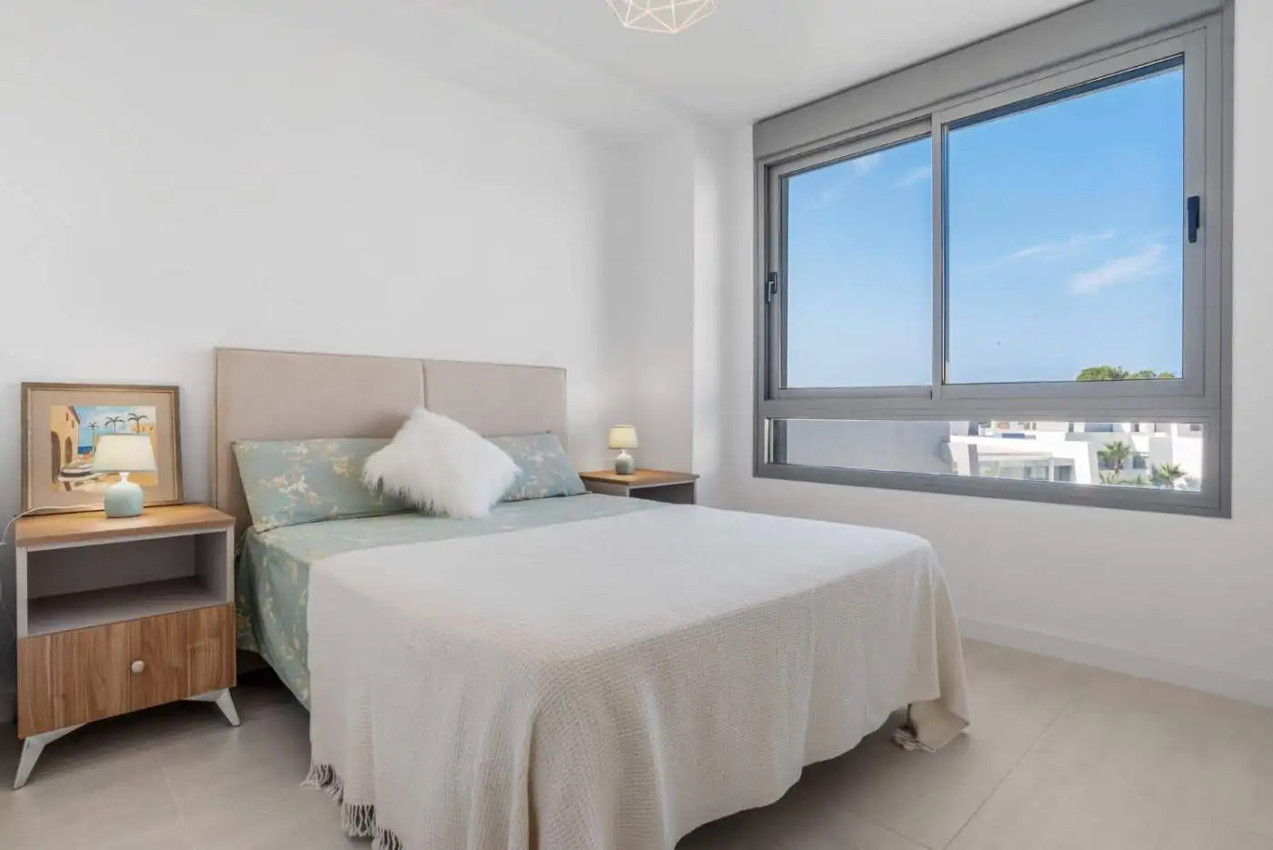 Bright bedroom of a modern 2-bedroom penthouse with large window and sea view in Selwo Estepona.