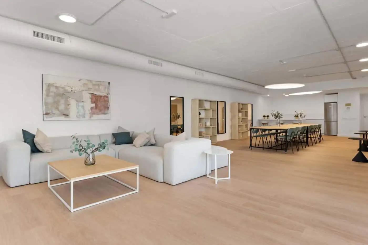 Spacious modern living room with white sofa, wooden flooring, and minimalist decor in Selwo Estepona.