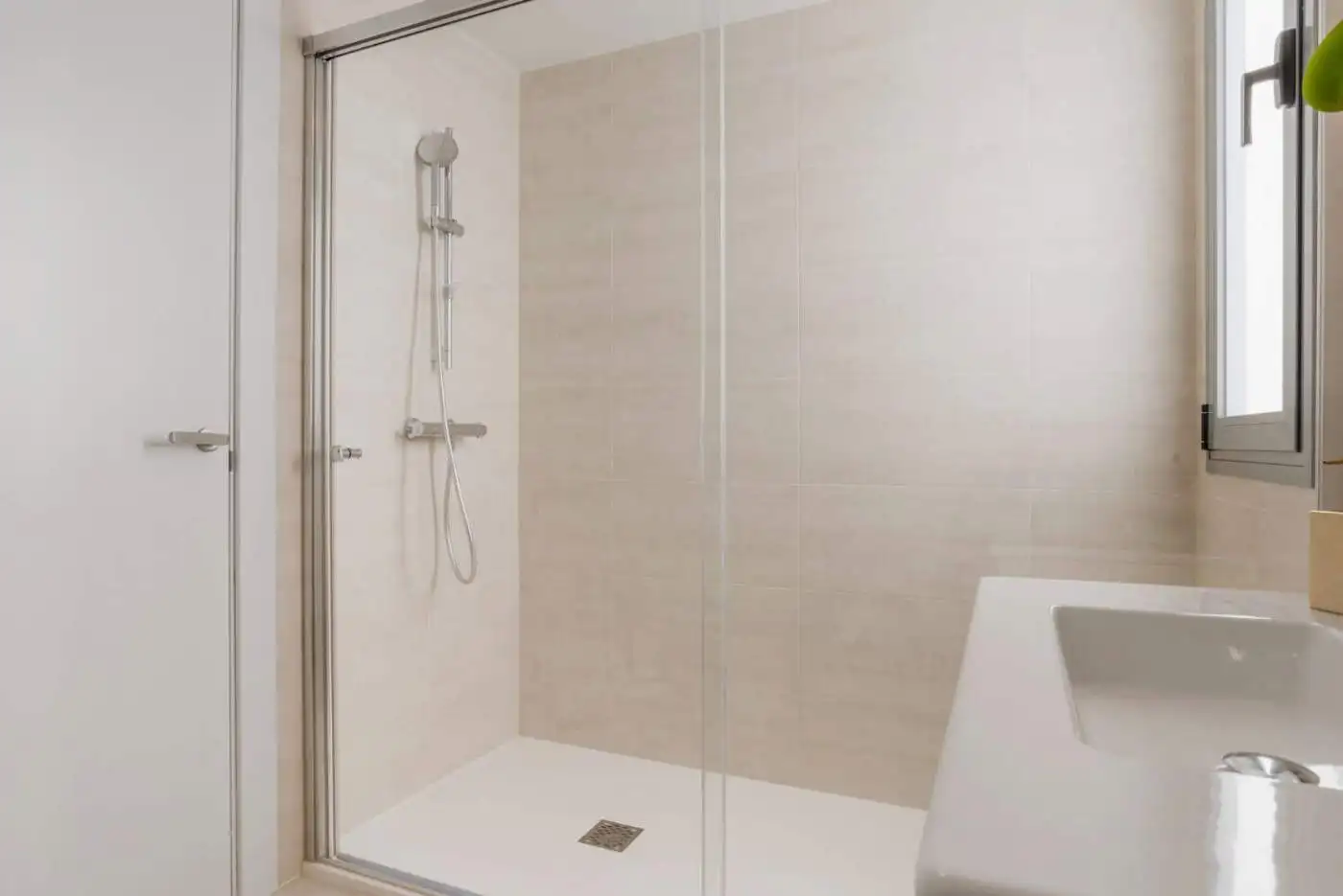 Modern shower with glass enclosure in a spacious bathroom of a 2-bedroom penthouse.