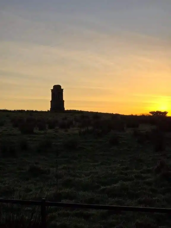 Landmark tower silhouette against a sunset sky in Castlerock, County Derry, Northern Ireland.