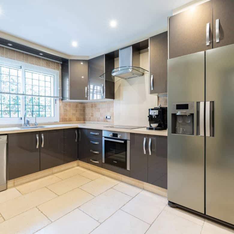 Bright, fully equipped kitchen with stainless steel appliances in a refurbished townhouse.