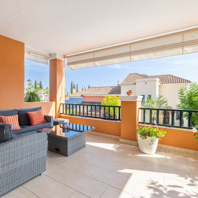 Balcony of a refurbished townhouse in Brisas del Sur, Nueva Andalucía, with outdoor seating and scen.