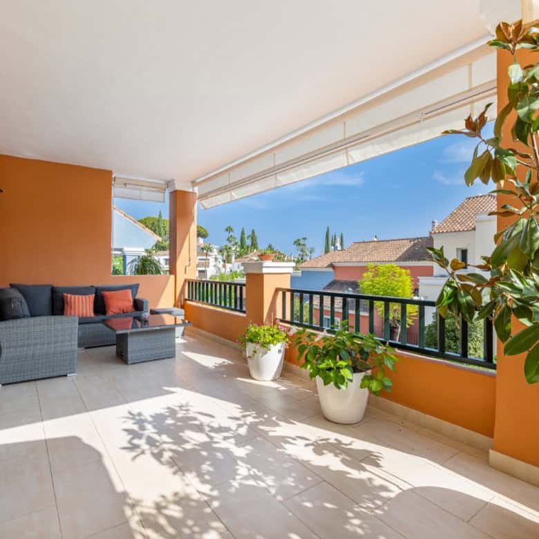 Balcony of a refurbished townhouse in Brisas del Sur, Nueva Andalucía, with outdoor seating and scen.