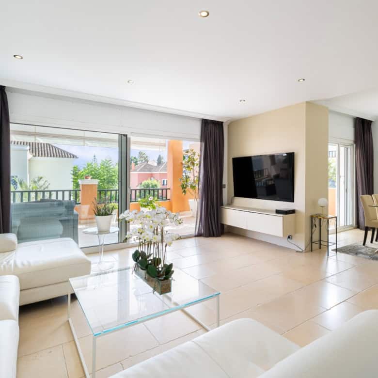 Bright and spacious living area with large glass doors opening to a balcony in Brisas del Sur, Nueva.