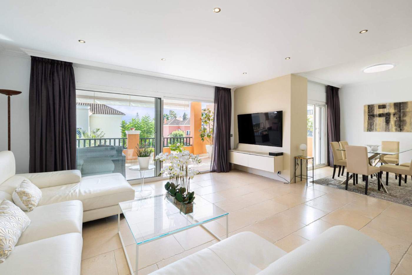 Modern living room with balcony view in Brisas del Sur townhouse Bright and spacious living area with large glass doors opening to a balcony in Brisas del Sur, Nueva.