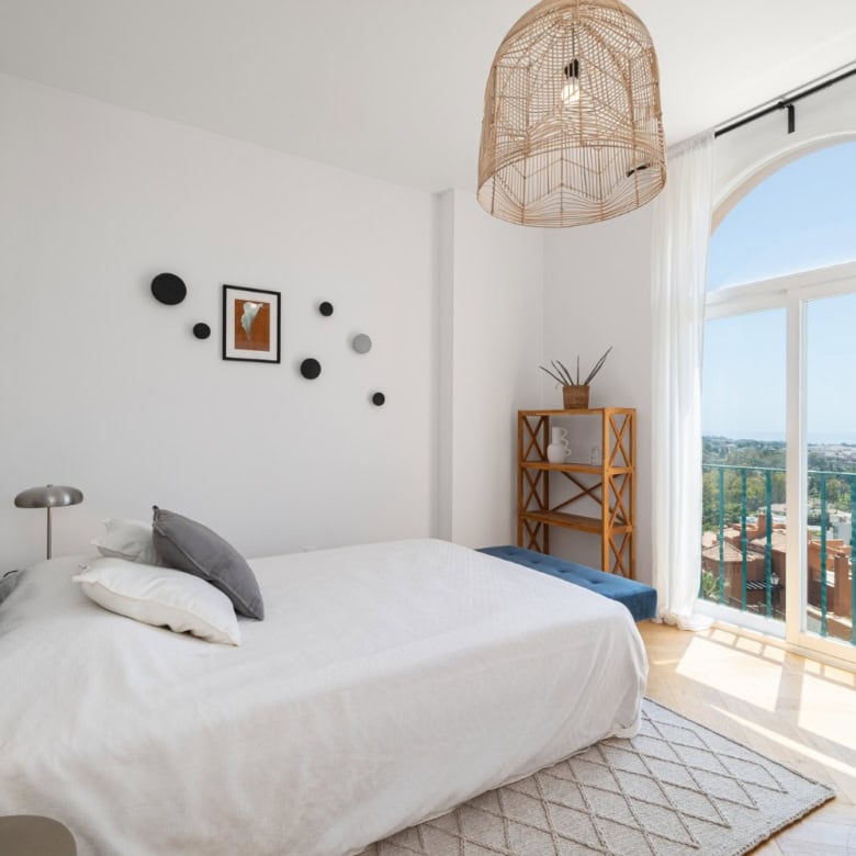 Penthouse bedroom with large window and city views.