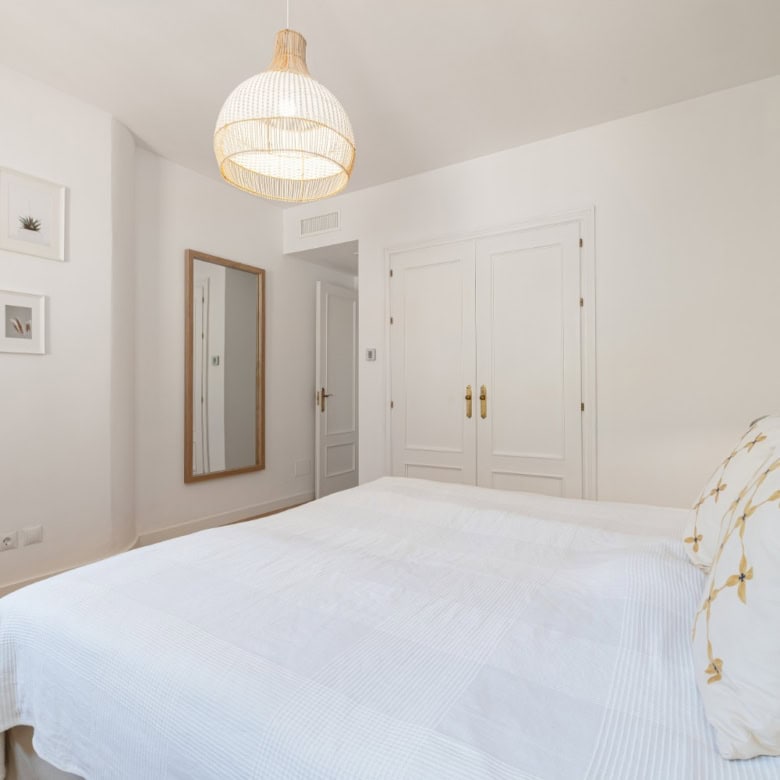 Bright, modern bedroom with panoramic south-facing windows and stylish decor.