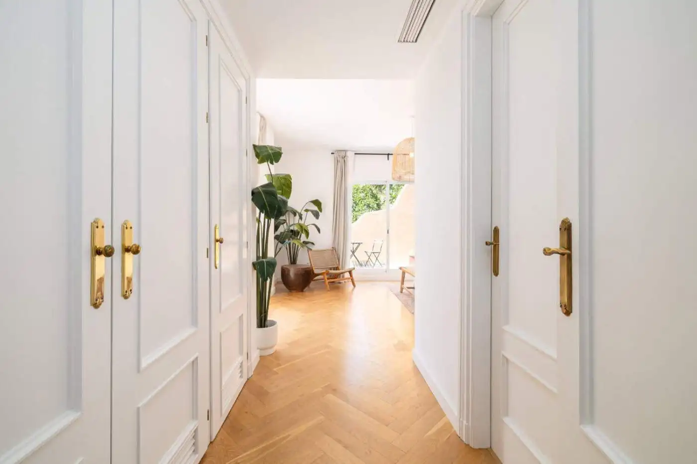 Bright hallway leading to a stylish living area with large windows and panoramic city views.