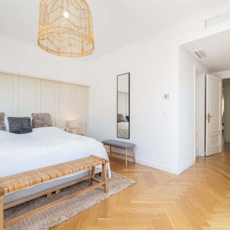Luxurious penthouse bedroom with modern decor and panoramic south-facing windows.