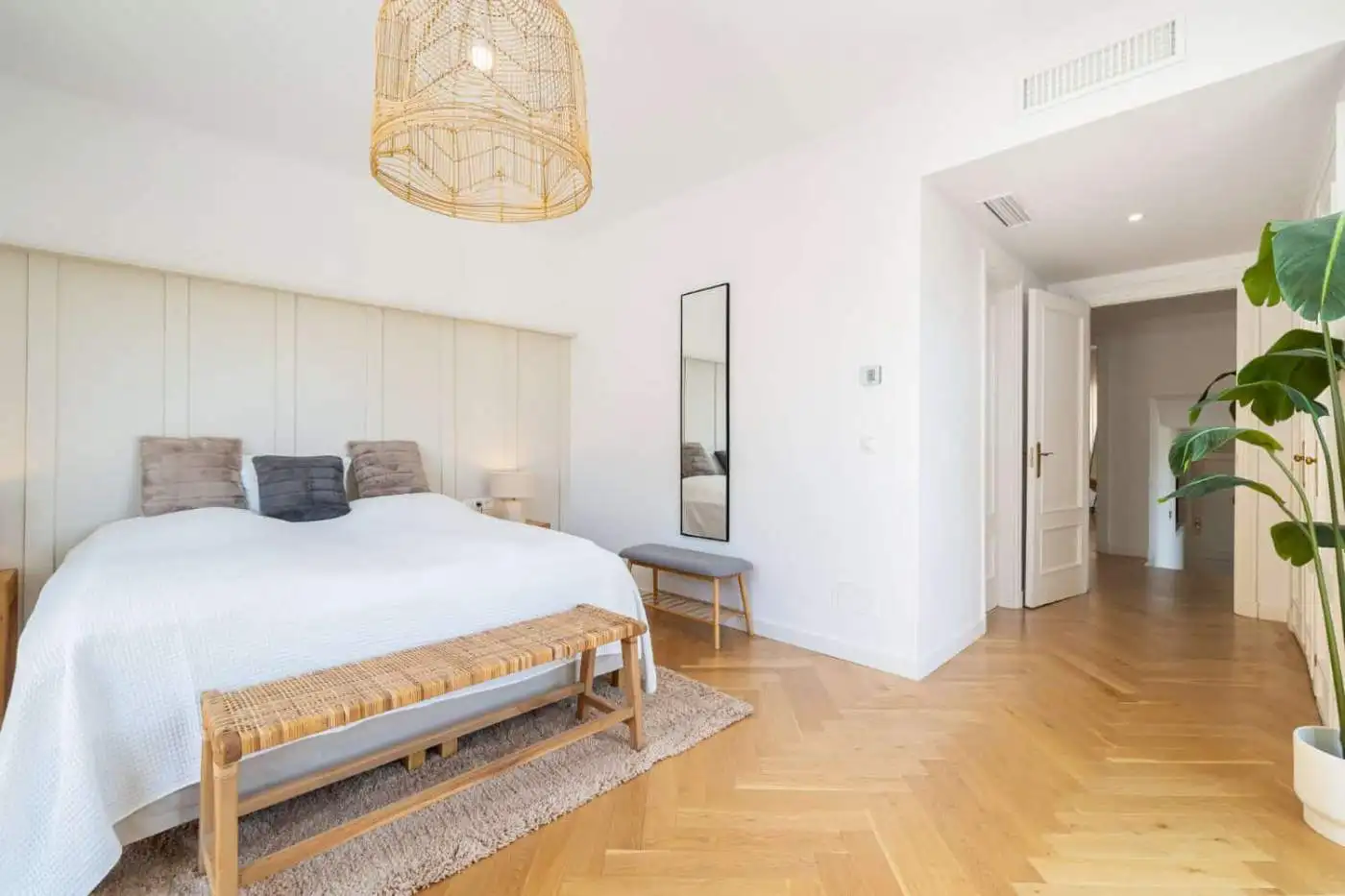 Luxurious penthouse bedroom with modern decor and panoramic south-facing windows.