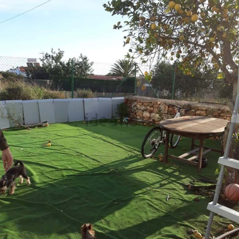 Beautiful outdoor area of a villa estate with two houses, featuring a green lawn, outdoor furniture,.