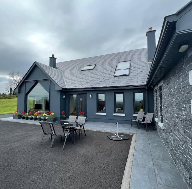 Stylish contemporary house with outdoor dining area and scenic landscape.