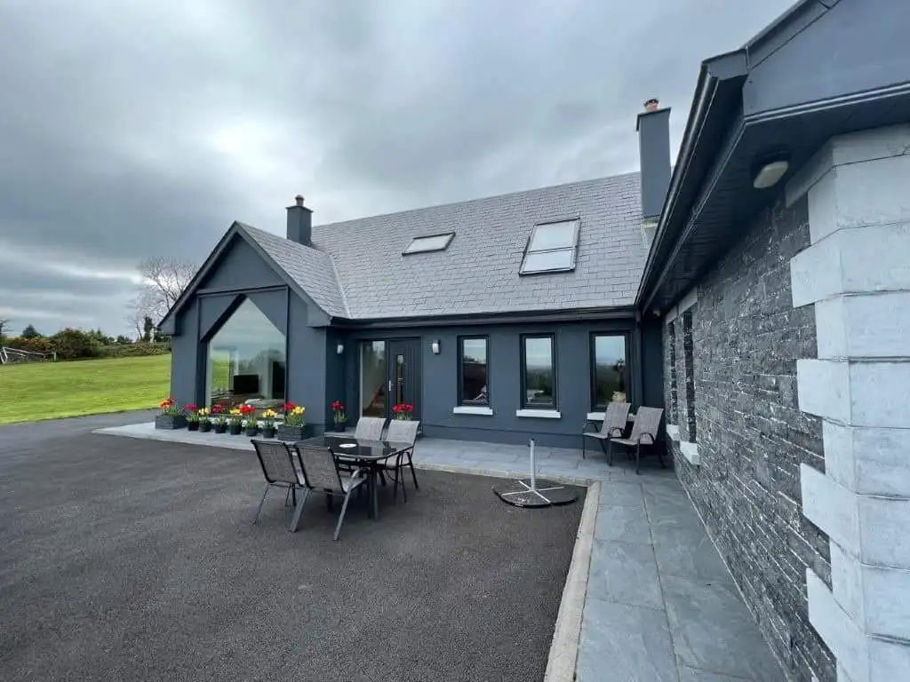 Stylish contemporary house with outdoor dining area and scenic landscape.